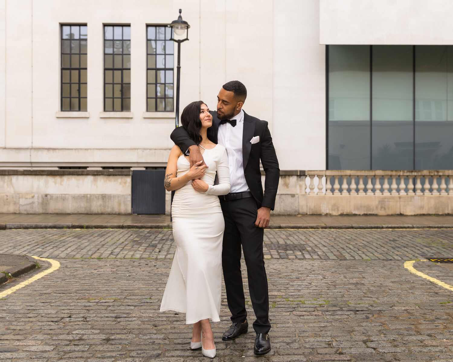 Romantic wedding couple embracing on cobblestone street in London, captured by Vanessa Sterling Photography